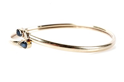 Lot 173 - A sapphire set crossover bangle