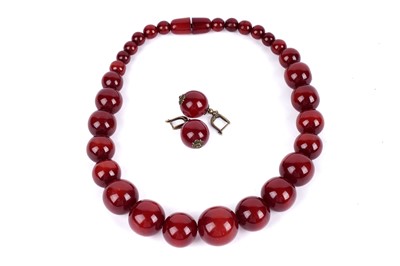 Lot 112 - A cherry amber style bead necklace; and a pair of similar earrings