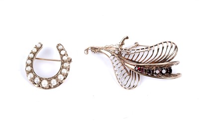 Lot 197 - A split pearl horseshoe pattern brooch; and a garnet spray brooch