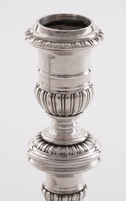 Lot 66 - A pair of William III silver cast candlesticks