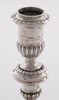 Lot 66 - A pair of William III silver cast candlesticks