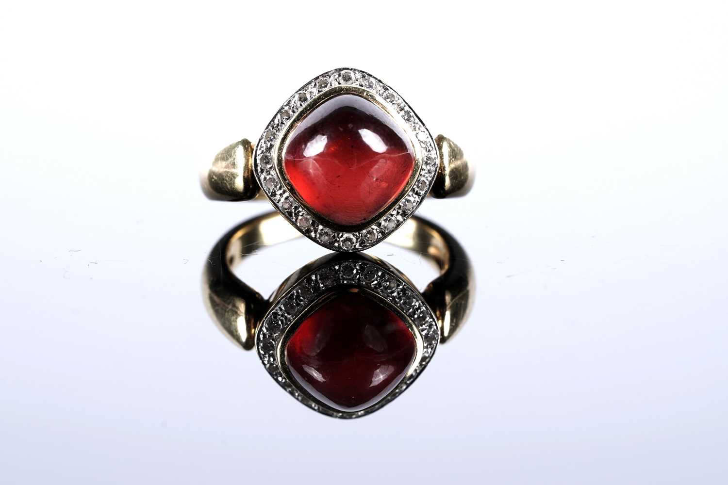 Lot 579 - A garnet cabochon and diamond cluster ring