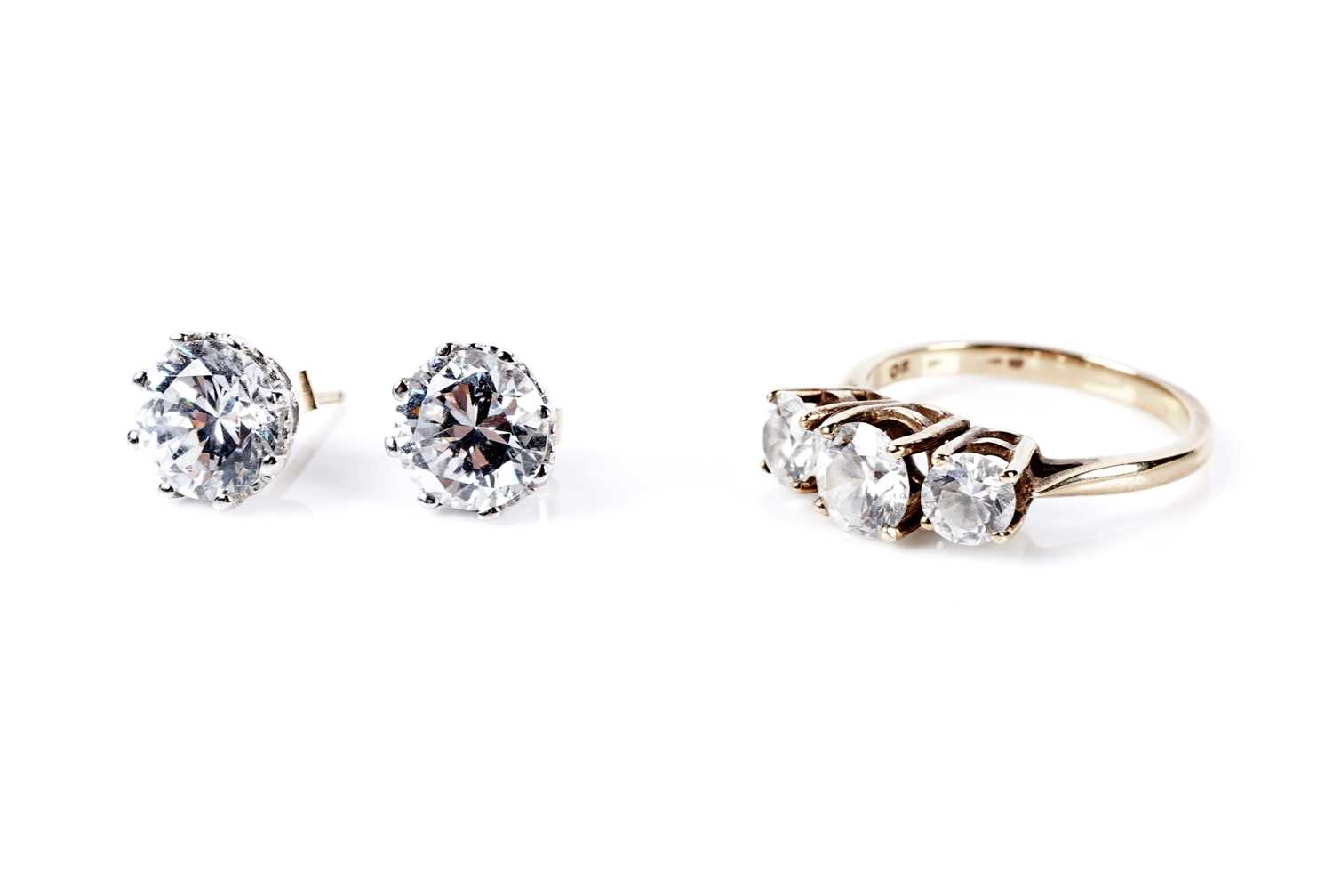 Lot 77 - A three stone dress ring; and a pair of stud earrings