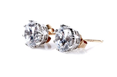 Lot 77 - A three stone dress ring; and a pair of stud earrings