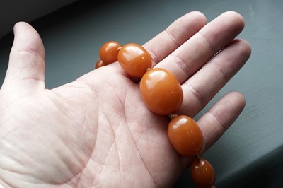 Lot 672 - An amber style bead necklace