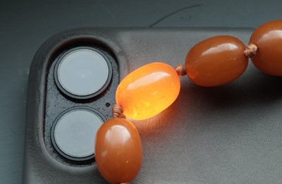 Lot 672 - An amber style bead necklace