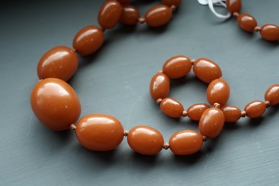 Lot 672 - An amber style bead necklace