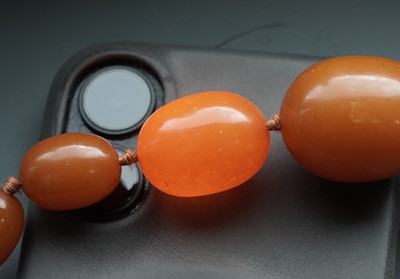 Lot 672 - An amber style bead necklace