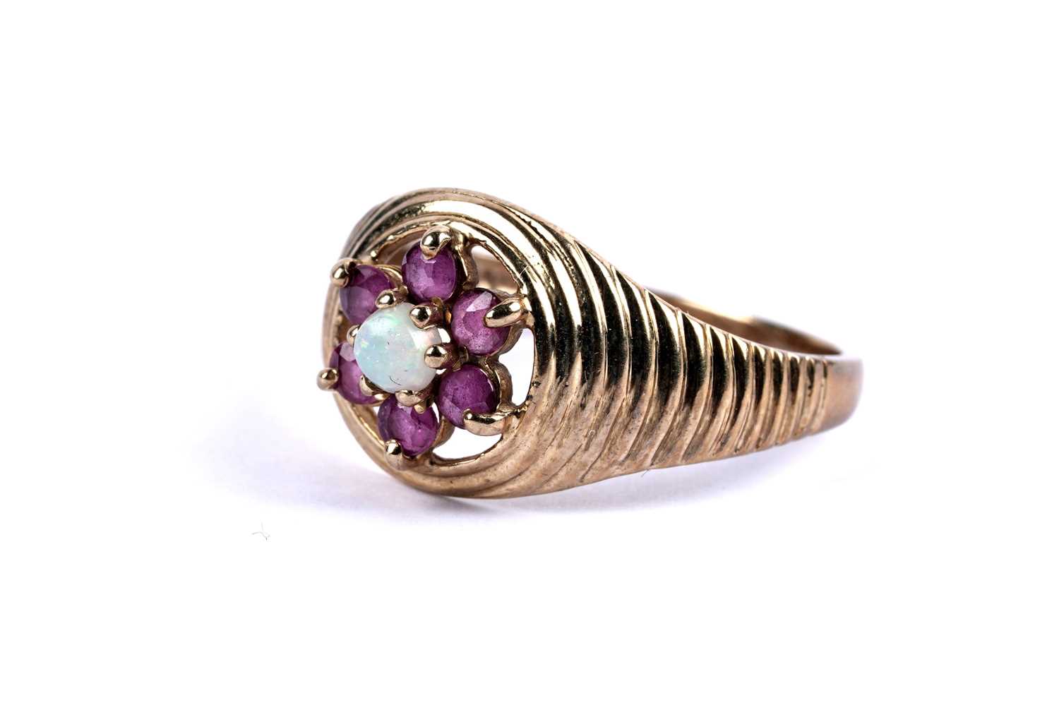 Lot 99 - An opal and ruby flower cluster ring