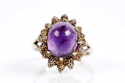 Lot 617 - An amethyst cabochon dress ring
