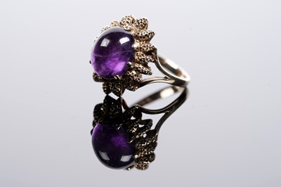 Lot 617 - An amethyst cabochon dress ring