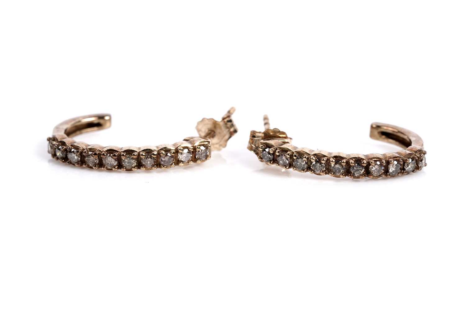 Lot 611 - A pair of diamond half hoop earrings