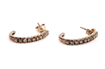 Lot 611 - A pair of diamond half hoop earrings