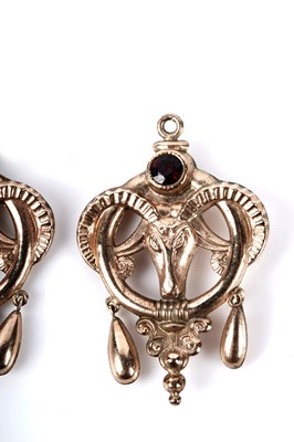 Lot 160 - A pair of garnet set ram's head pattern charm pendants; and an earring