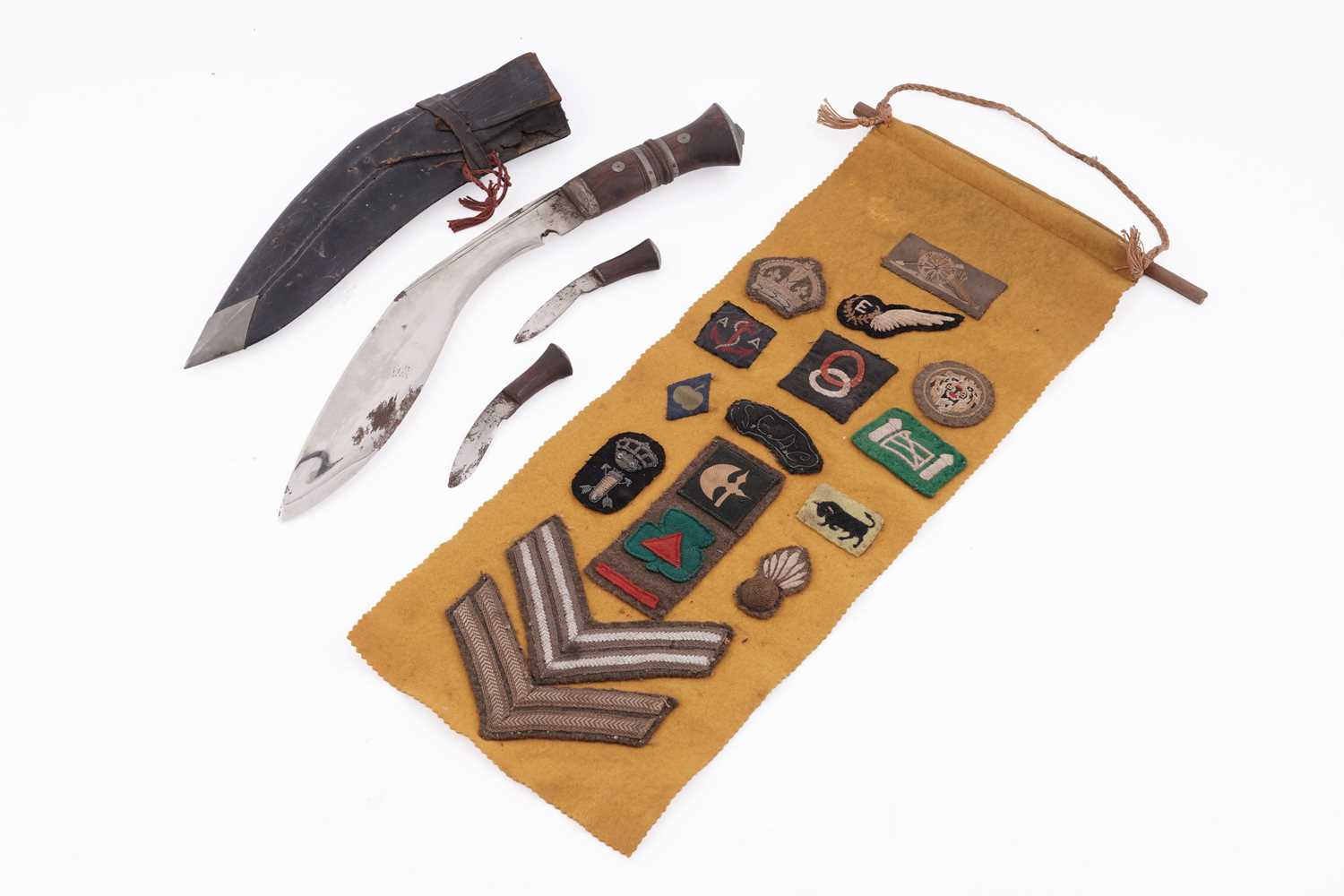 Lot 121 - An early 20th Century Kukri; and a collection of cloth military badges