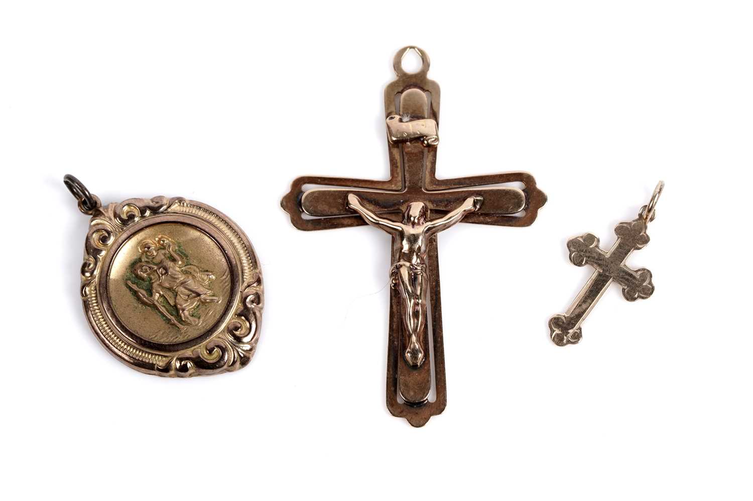 Lot 650 - Two gold crucifix pendants; and a St Christopher pendant