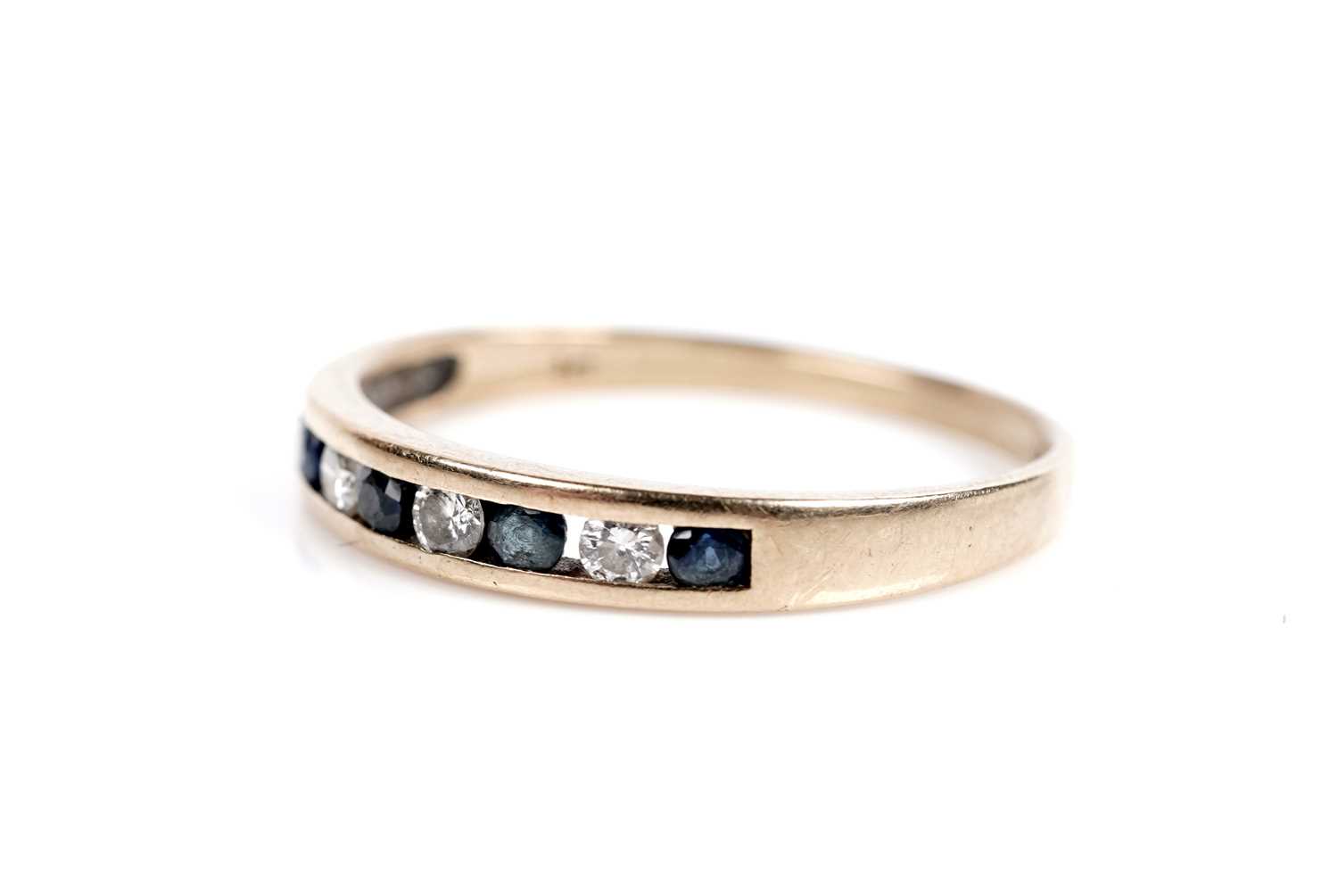 Lot 652 - A sapphire and diamond half eternity ring