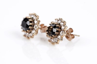 Lot 645 - A pair of sapphire and white stone cluster earrings