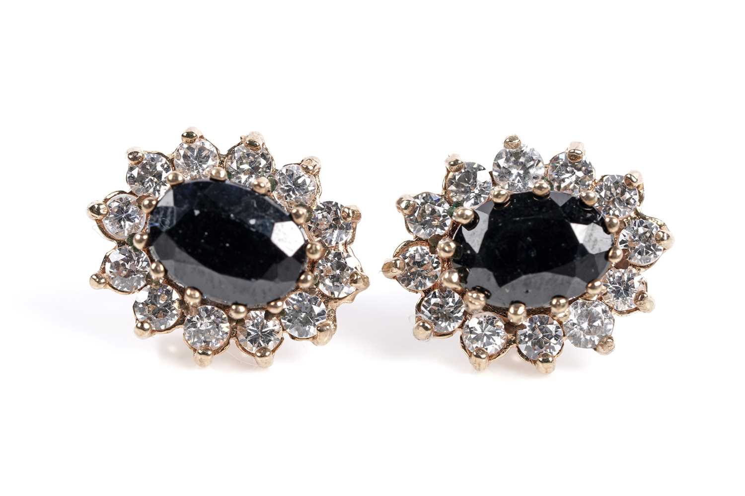 Lot 645 - A pair of sapphire and white stone cluster earrings