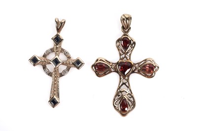 Lot 687 - A sapphire and diamond crucifix pendant and a garnet crucifix pendant