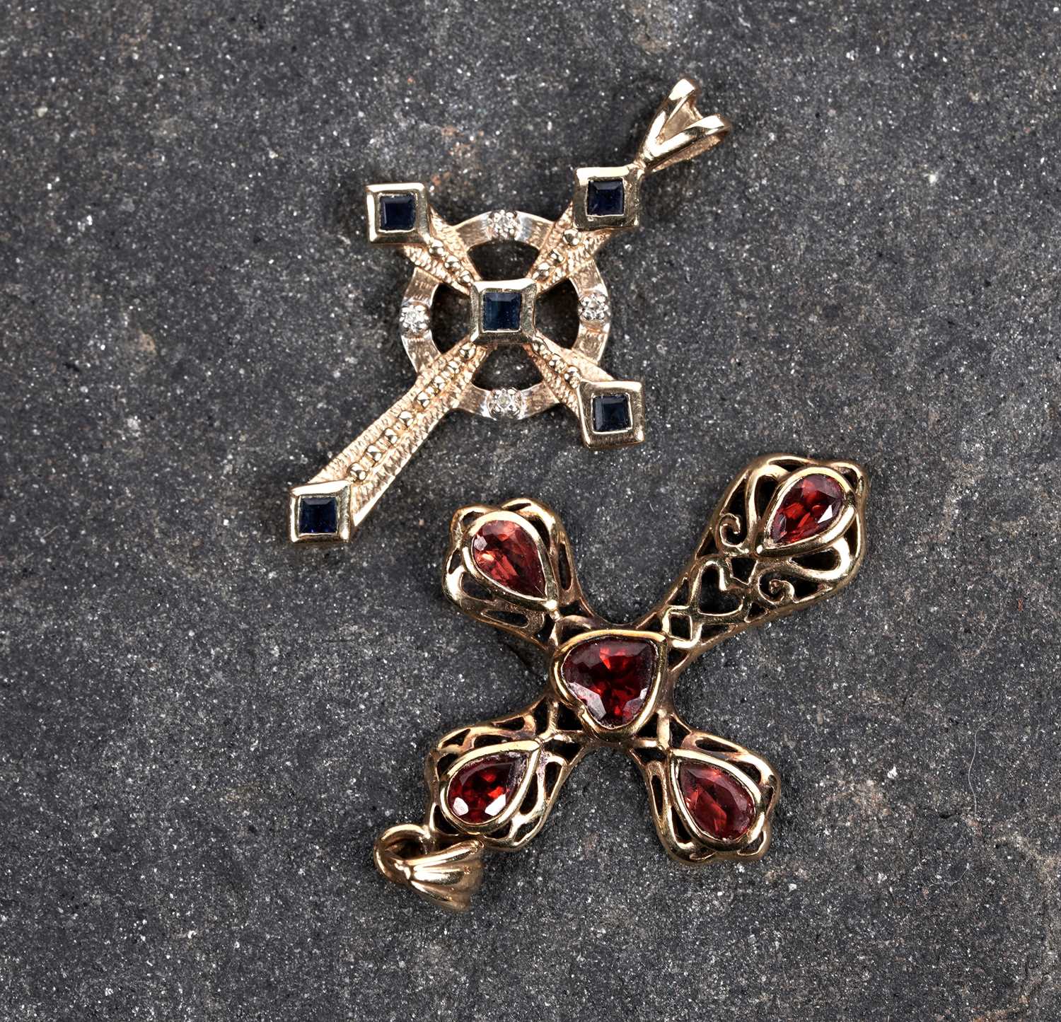 Lot 687 - A sapphire and diamond crucifix pendant and a garnet crucifix pendant