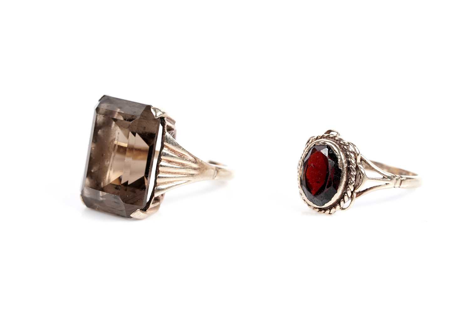 Lot 625 - A smoky quartz cocktail ring; and a garnet single stone ring