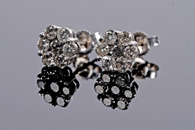 Lot 689 - A diamond flower cluster pendant and earring set