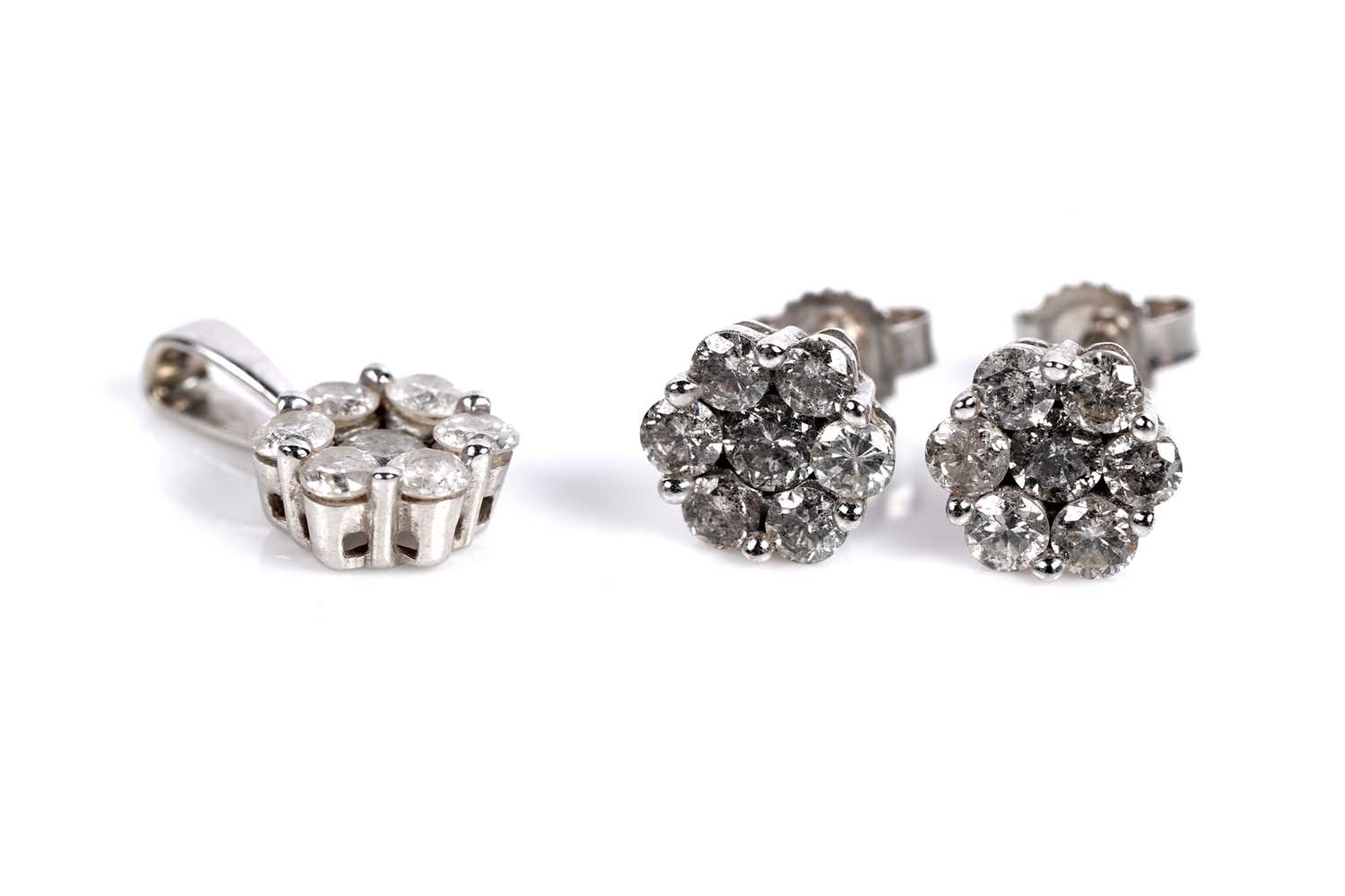 Lot 689 - A diamond flower cluster pendant and earring set