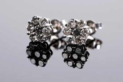 Lot 689 - A diamond flower cluster pendant and earring set