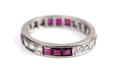 Lot 585 - A ruby and diamond eternity ring