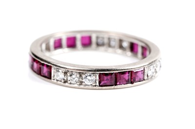 Lot 585 - A ruby and diamond eternity ring