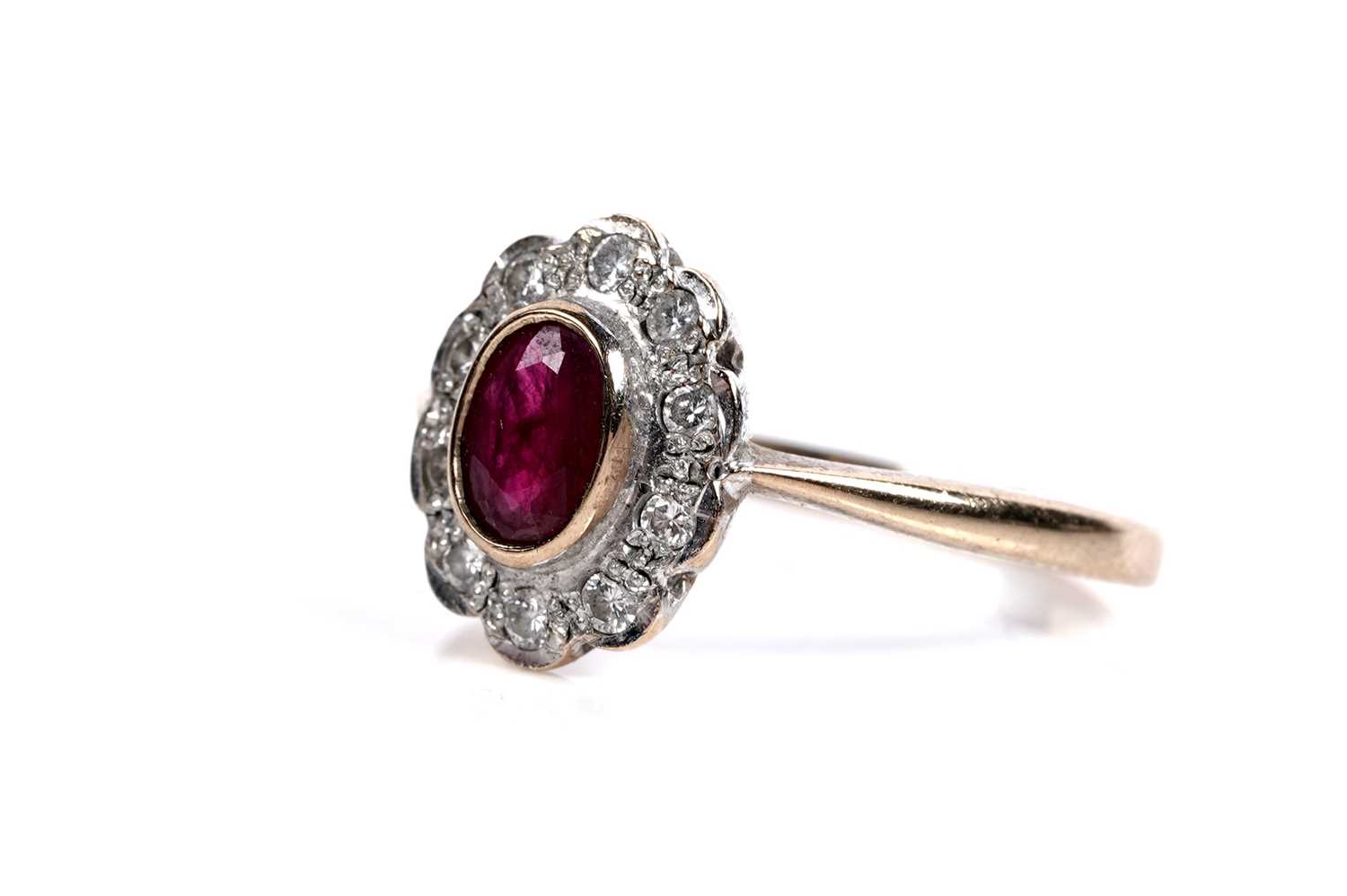 Lot 556 - A ruby and diamond flowerhead pattern ring