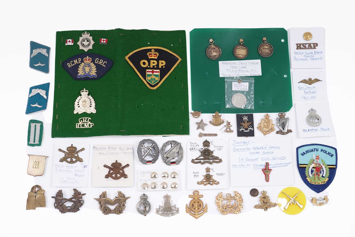 Lot 200 - A selection of foreign and commonwealth military cap badges, buttons and other items