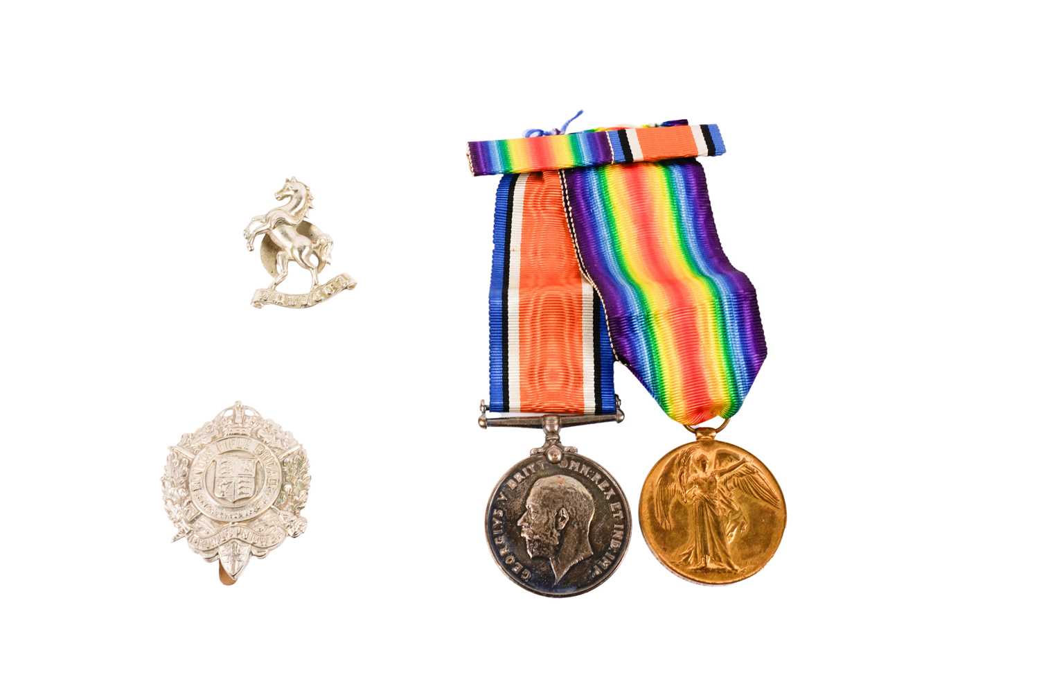 Lot 216 - A pair of First World War general service medals; and two cap badges
