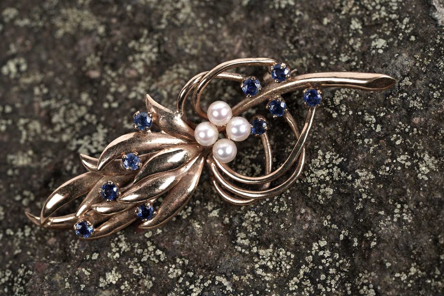Lot 518 - A sapphire and pearl stylized sprig brooch