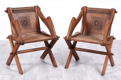 Lot 32 - Local interest: a pair of Edwardian carved oak ecclesiastical Glastonbury armchairs