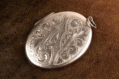 Lot 97 - A 1970's 9ct gold locket with engraved decoration