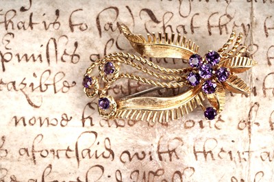 Lot 212 - An amethyst brooch in the form of a stylized floral sprig