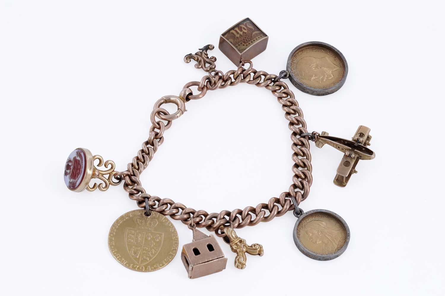 Lot 313 - A 9ct rose gold charm bracelet, with fob George III 1794 gold guinea, and sovereigns