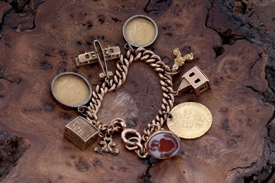 Lot 313 - A 9ct rose gold charm bracelet, with fob George III 1794 gold guinea, and sovereigns