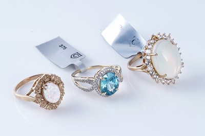 Lot 196 - Two synthetic opal rings; and a blue-topaz and white stone ring