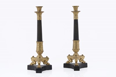 Lot 1029 - A pair of French Empire style gilt and patinated bronze candlesticks