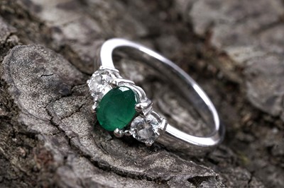 Lot 55 - An emerald and lab diamond three stone ring