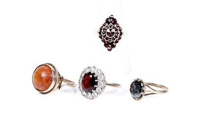 Lot 186 - Three 9ct yellow gold rings; and a garnet cluster ring