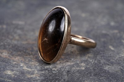 Lot 62 - A 1920's tiger's eye and gold cabochon ring