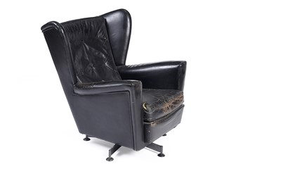 Lot 534 - A 1950’s black leather wingback revolving armchair