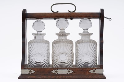 Lot 380 - An Edwardian oak three bottle Tantalus