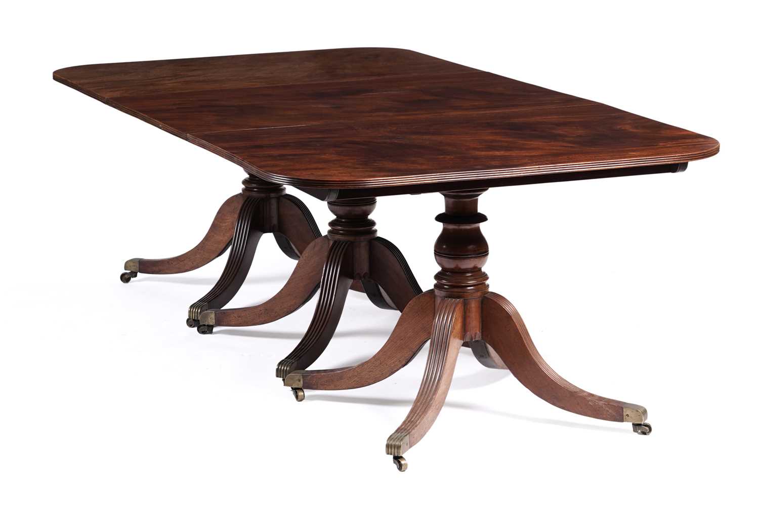 Lot 1057 - A Regency style mahogany three pillar pedestal dining table