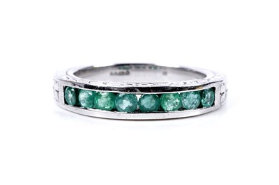 Lot 98 - A modern emerald half hoop eternity ring