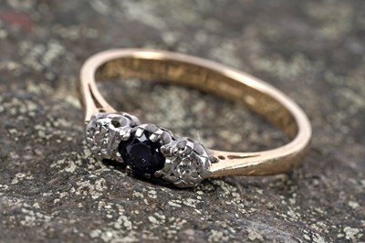 Lot 92 - A modern three stone sapphire and diamond ring